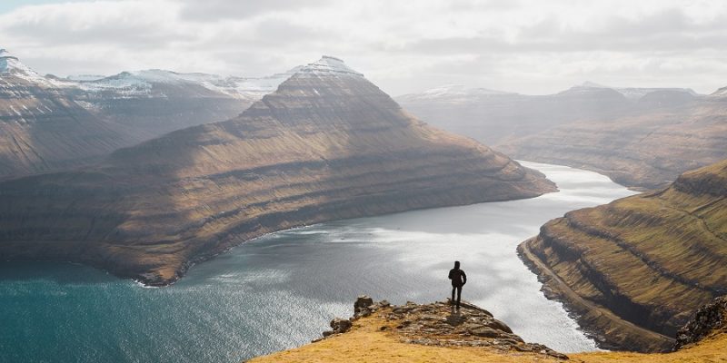 Färör Inseln Person guckt über die Berge und das Meer