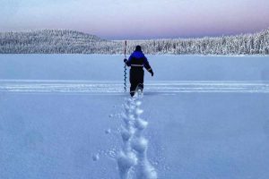 Fussstapfen-im-Schnee-waehrend-eine-Person-gen-Sonnenuntergag-laeuft-in-Finnisch-Lappland-©Ingrid-de-Jager