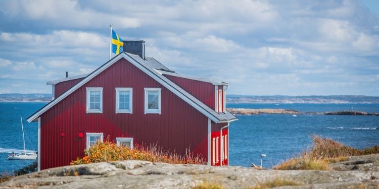 Rotes-Haus-in-Schweden-mit-Flagge-Reisen-mit-Nordic