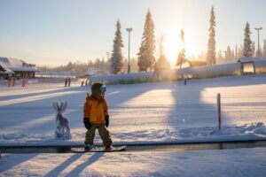 Kind-auf-Snowboard-in-Ruka-Kuusamo-in-Finnisch-Lappland-Reisen-mit-Nordic-der-Skandinavien-Spezialist_rukaskiresort_familypark_SallaKarhumaa