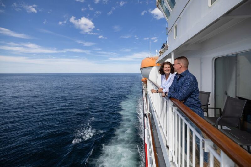 Paar-auf-dem-Deck-eines-Hurtigruten-Schiffs-entlang-der-norwegischen-Kueste-Reisen-mit-Nordic-der-Skandinavien-Spezialist