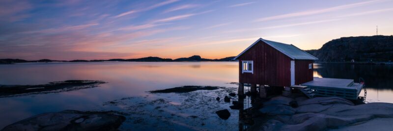 Ein-typisches-Haus-auf-dem-Wasser-an-der-Kueste-von-Bohuslan-in-Westschweden-bei-Sonnenuntergang-Reisen-mit-Nordic-der-Skandinavien-Spezialist